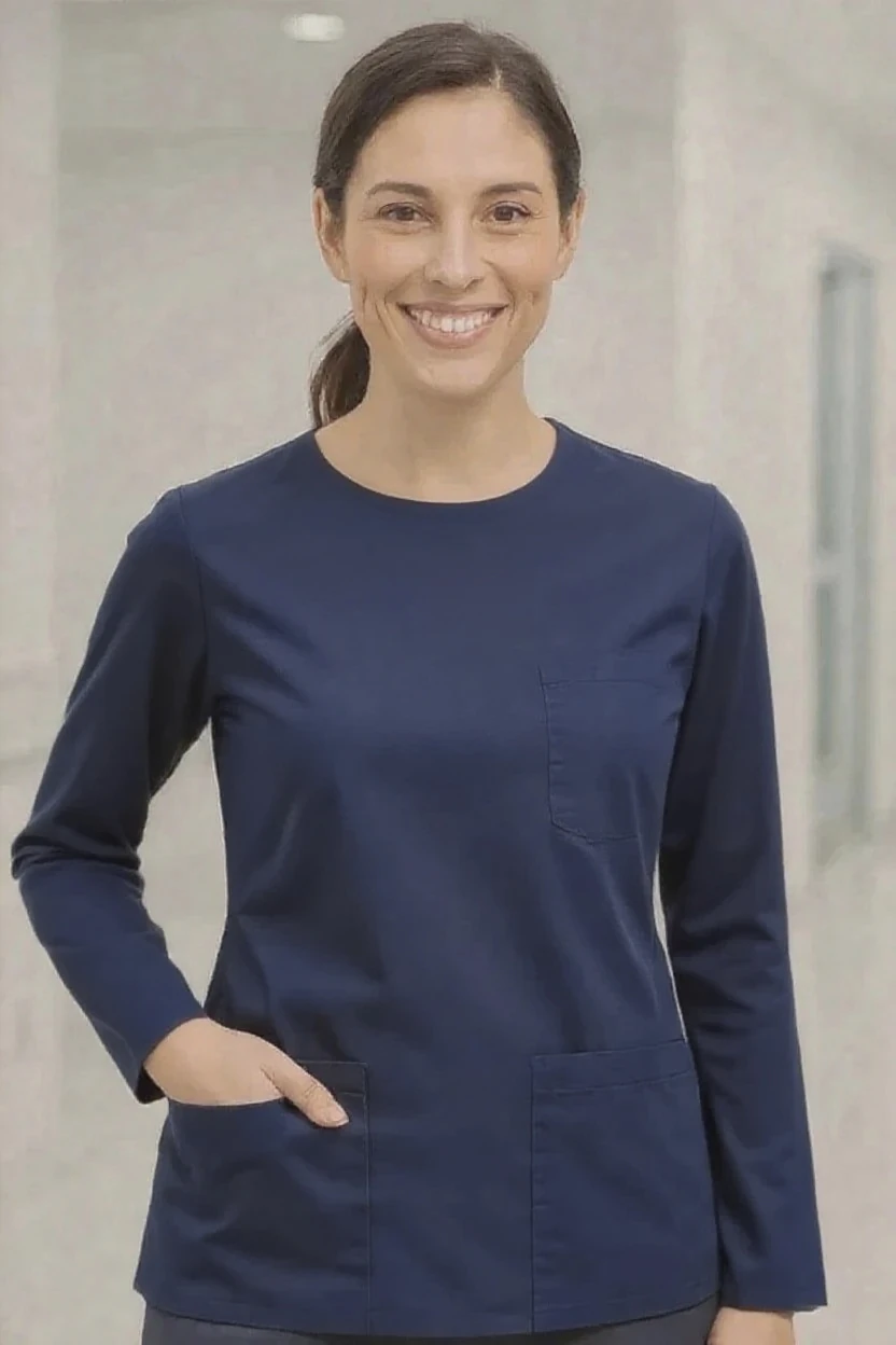 Woman wearing a navy blue scrub top with a neutral background
