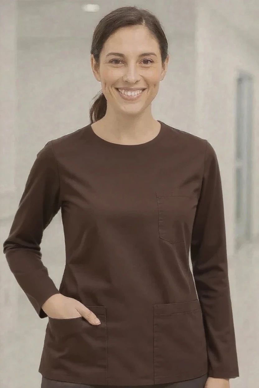 Woman wearing a brown scrub top in an indoor setting